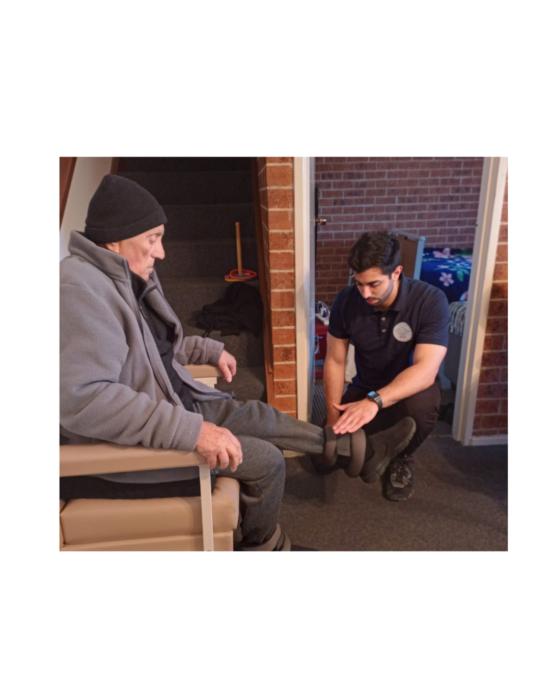 Physiotherapist assisting elderly client with leg brace adjustment during home physiotherapy visit