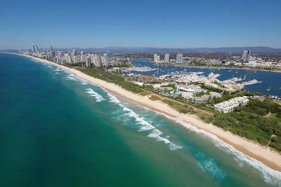 Aerial view of Main Beach, Gold Coast, showing the coastline, marina, and nearby high-rise buildings under a clear blue sky – ideal for promoting mobile physiotherapy services in the Main Beach area.