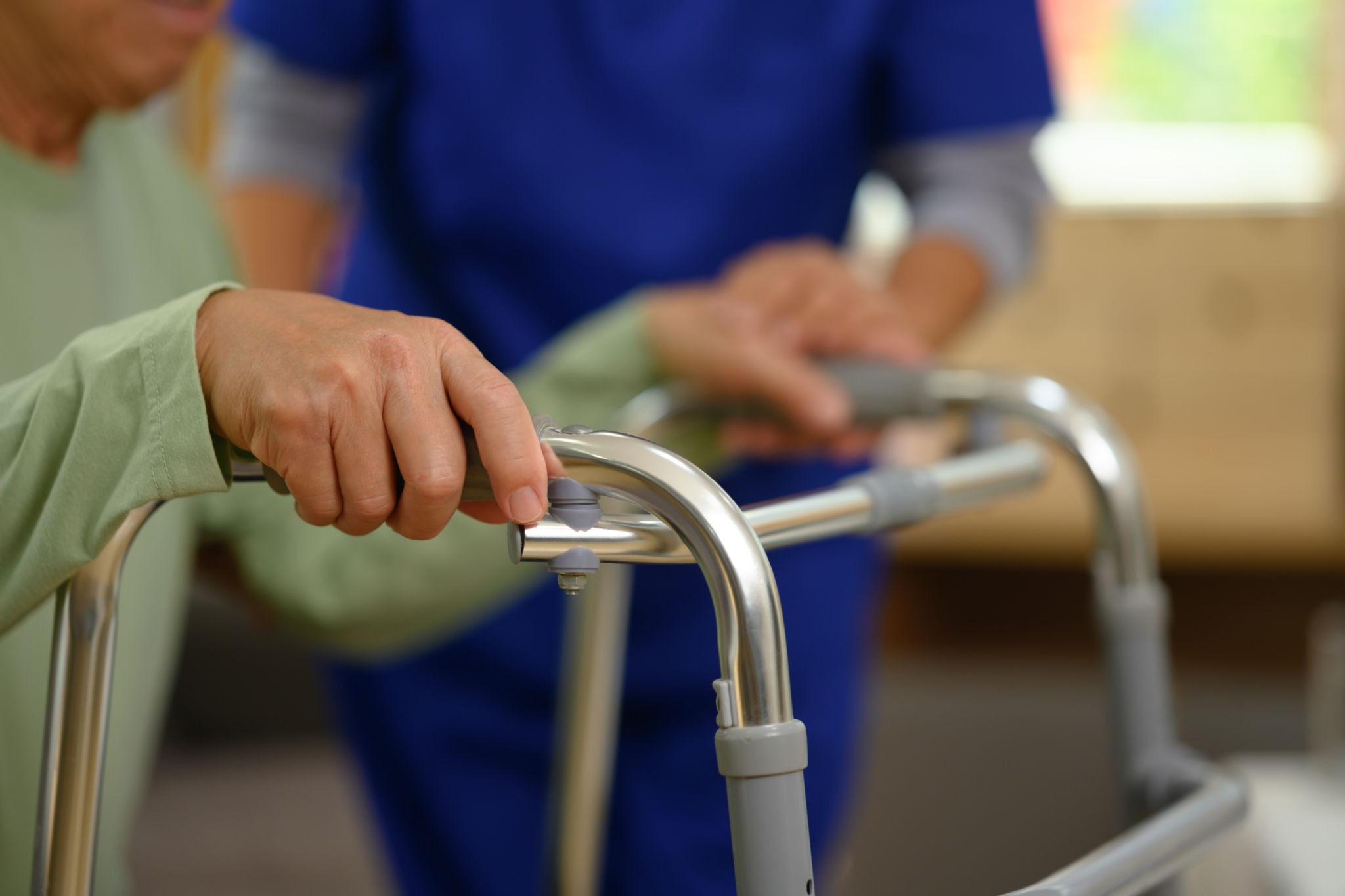 Physiotherapist Helping Patient With Walking Aid in Home
